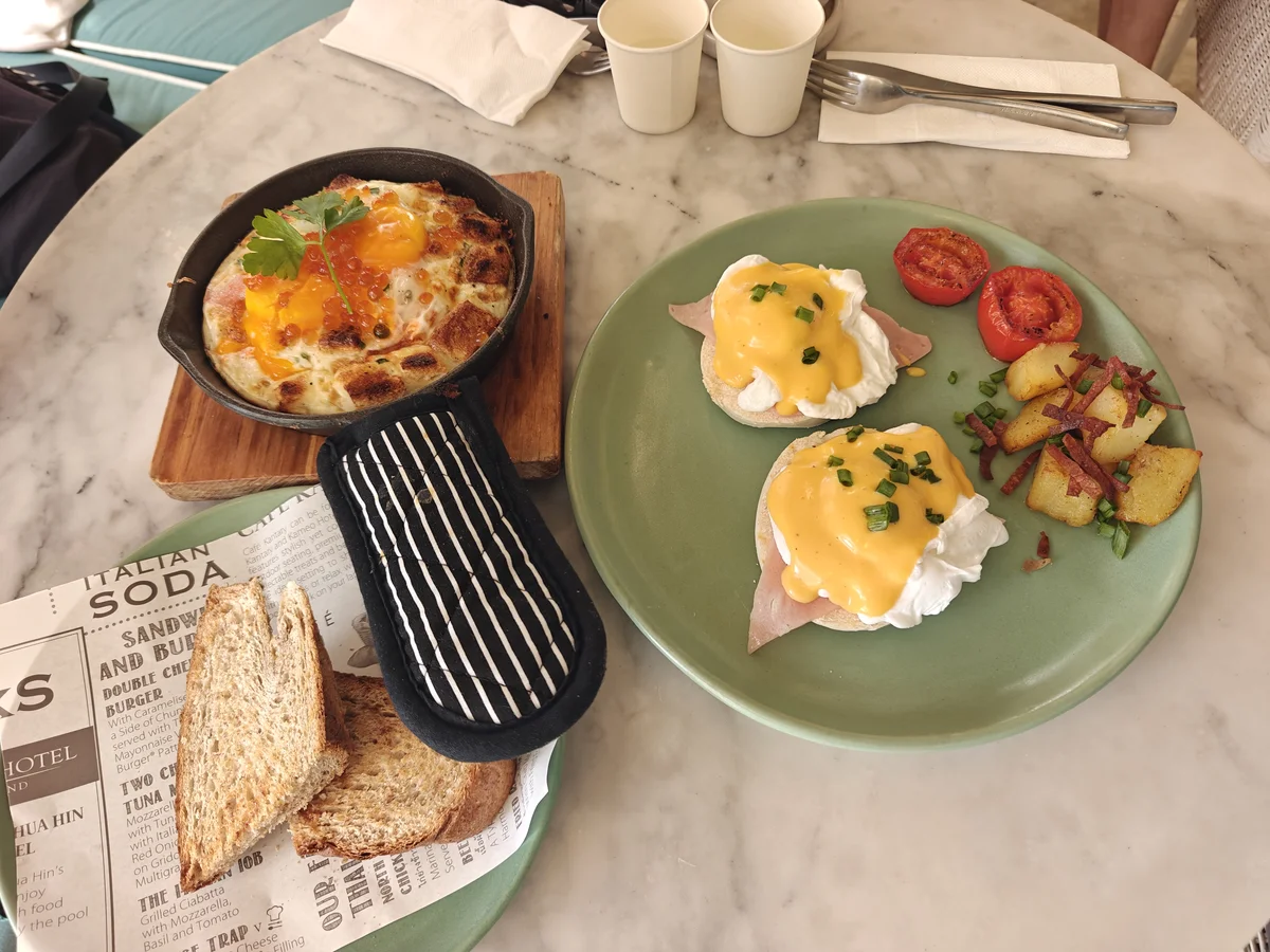 Two plates, two philosophies — one egg baked in cast iron with salmon roe like it has something to prove, one quietly doing the Benedict thing it was born to do.