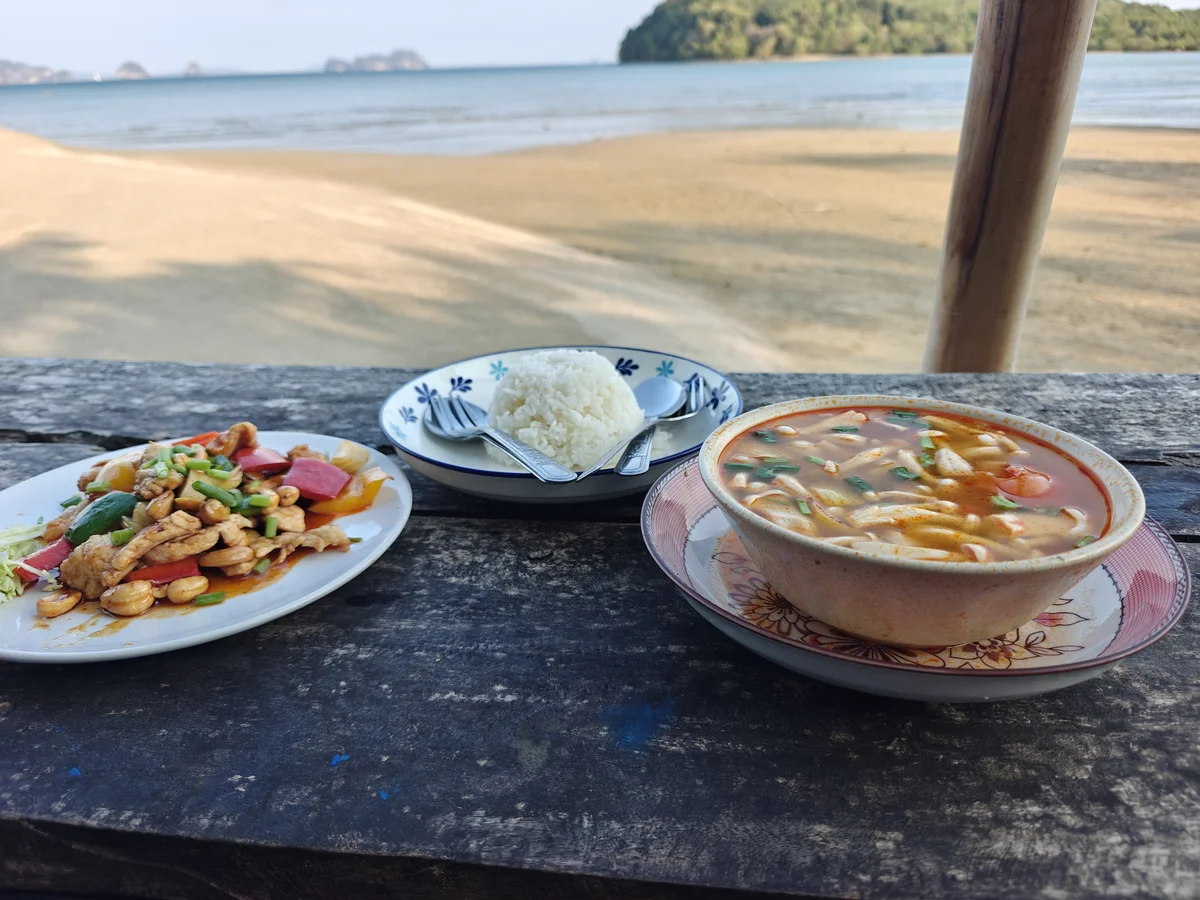 Cashew chicken stir-fry, tom kha, steamed rice, and a view that costs approximately nothing — the smug meal of someone making better decisions than you.