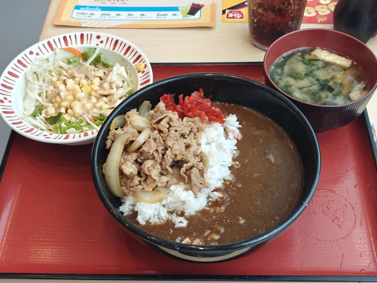 Gyudon curry set at lunch: beef and onions over rice, red pickled ginger, miso soup, side salad with corn.
