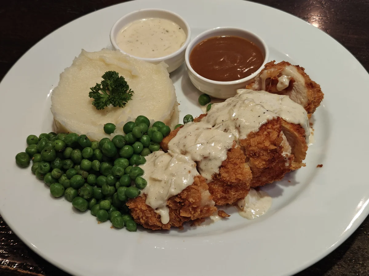 Chicken fried chicken, mashed potatoes, peas, white pepper gravy, and brown gravy on the side. Lunch in Bangkok.